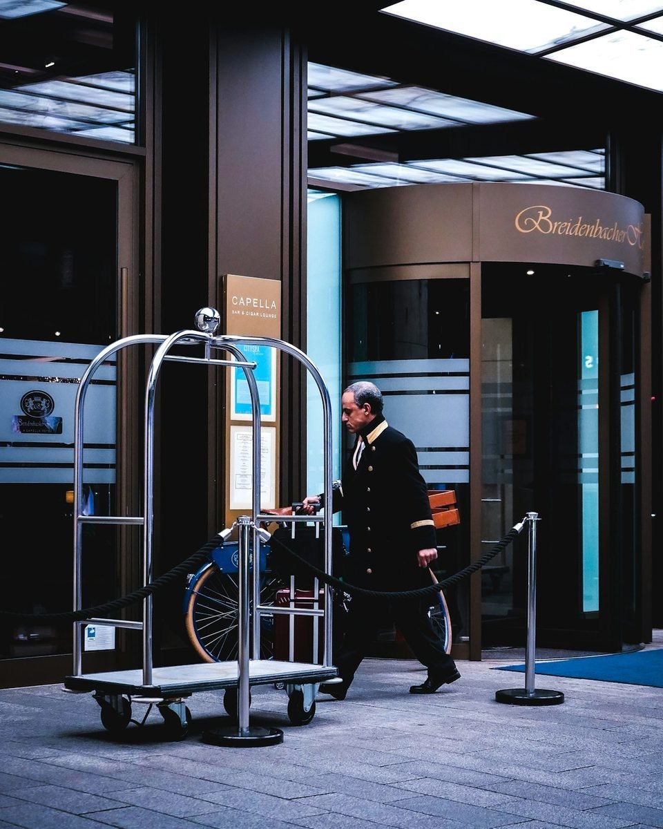 Executivo sendo retirado com bagagem na entrada do hotel